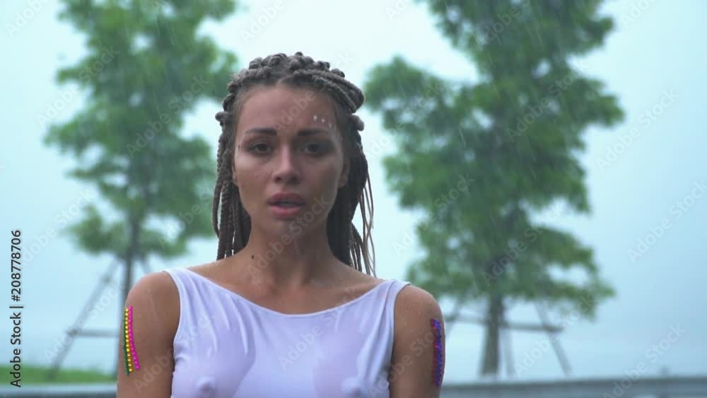 A sad attractive girl is standing and crying in the rain in a wet white  dress. Stock Video | Adobe Stock