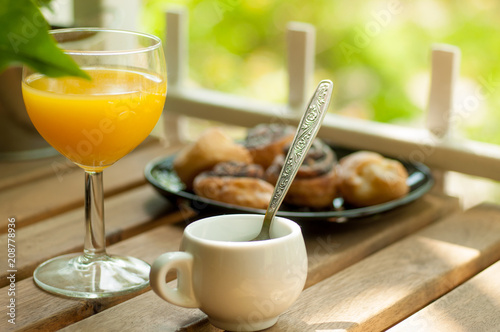 Outdoor breakfast with orange juice, espresso andbakery goods