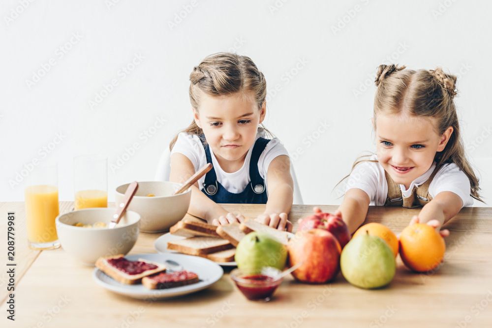 little sisters do not want to eat healthy breakfast isolated on white little sisters do not want to eat healthy breakfast isolated on white