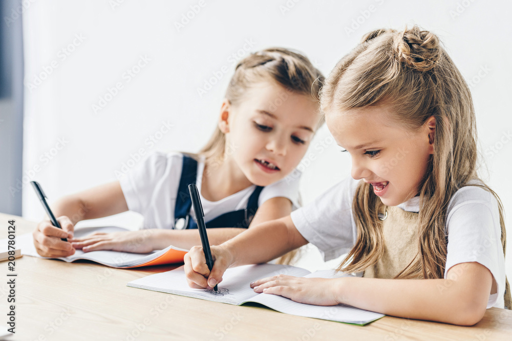 little schoolgirl cheating and copying work of her classmate isolated on white little schoolgirl cheating and copying work of her classmate isolated on white
