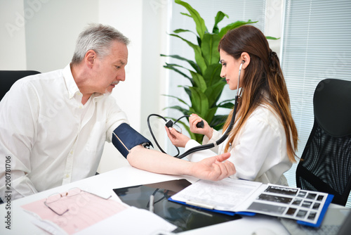 Doctor checking a patient blood pressure