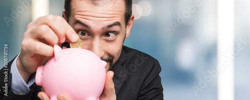 Businessman putting money in his piggy bank photo