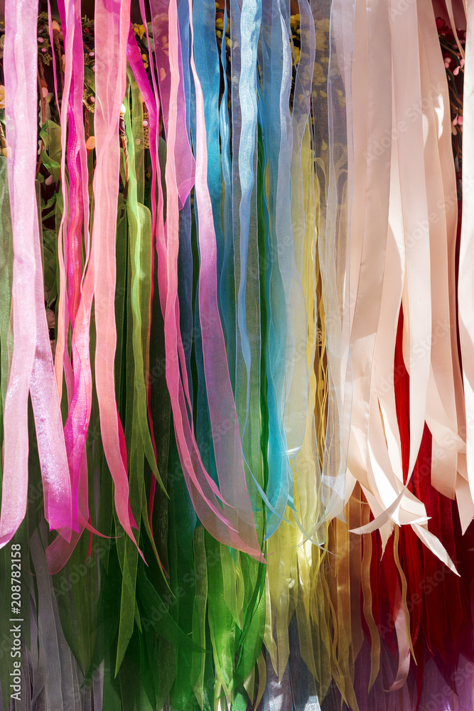 background of strips of silk fabric of various colors
