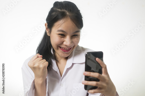 Delightful, happy emotional woman, closing her face with pleasure feeling excited while using smartphone.