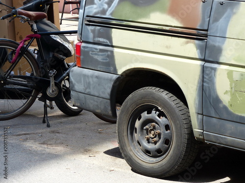 Alter Kleintransporter der deutschen Bundeswehr mit Camouflage Tarnanstrich und Schiebetür für Vanlife und Camping und altes Fahrrad bei Sonnenschein im Karolinenviertel in der Hansestadt Hamburg photo