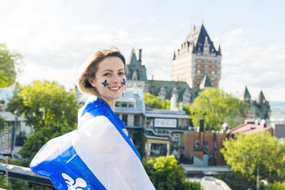 Naklejka premium Kobieta obchodzi święto narodowe przed Chateau Frontenac w Quebecu