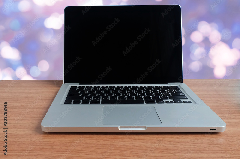 Laptop computer on wooden floor with blurred blue bokeh background Laptop computer on wooden floor with blurred blue bokeh background