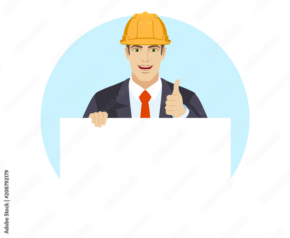 Businessman in construction helmet holding white blank poster and showing thumb up