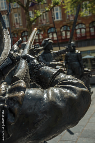 Bronze sculpture of XVII century soldier on the Rembrandt Square in a sunny day at Amsterdam. The city is famous for its huge cultural activity, graceful canals and bridges. Northern Netherlands.