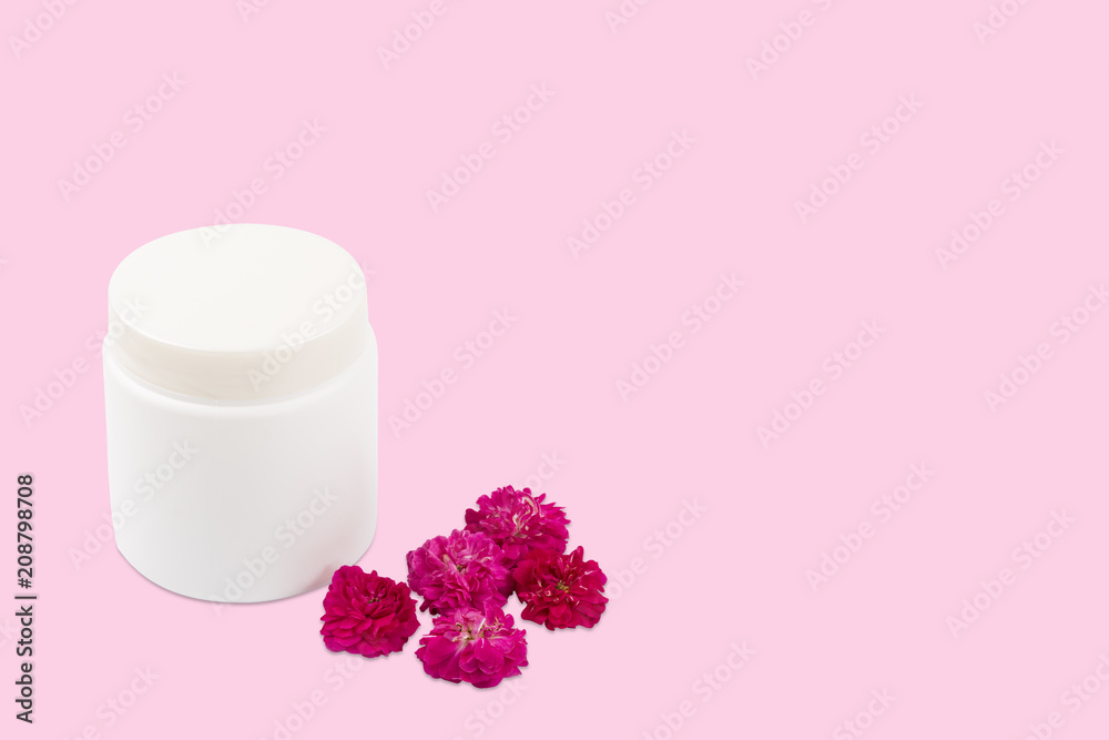 White mocap jar for cream, balm, lotion and a small pink-Red roses on a pink background. Isolated, closeup. flatlay, copyspace White mocap jar for cream, balm, lotion and a small pink-Red roses on a pink background. Isolated, closeup. flatlay, copyspace