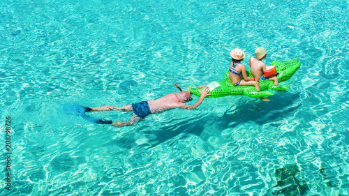 Obraz na płótnie A father spending funny moments with his kids on the sea of Mallorca, in summer holiday. w salonie