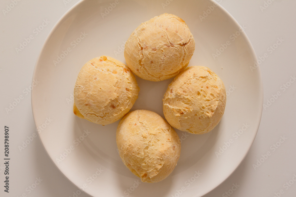 Pao de Queijo is a cheese bread ball from Brazil. Also known as Chipa, Pandebono and Pan de Yuca. Snacks over white plate, minimalism. Pao de Queijo is a cheese bread ball from Brazil. Also known as Chipa, Pandebono and Pan de Yuca. Snacks over white plate, minimalism.