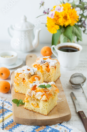 Apricot rustic cake on a table cut in square pieces