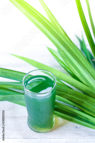 Glass of pandan juice and pandan leaves on white background.   