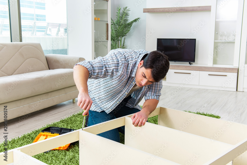 Man assembling furniture at home Man assembling furniture at home