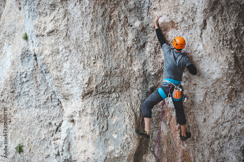 A man in helmet climbs the rock.