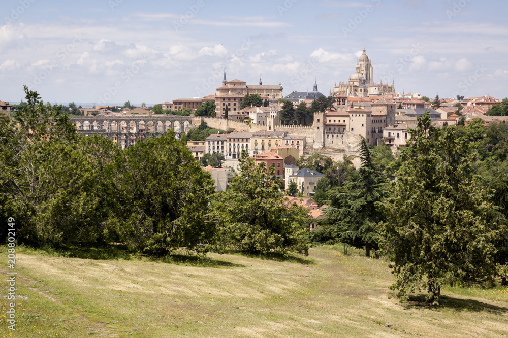 Photograph of monumental Segovia. Cathedral, aqueduct and historical center. Trees and plants in the spring season. Segovia, Castilla y Leon. Spain, Europe.
