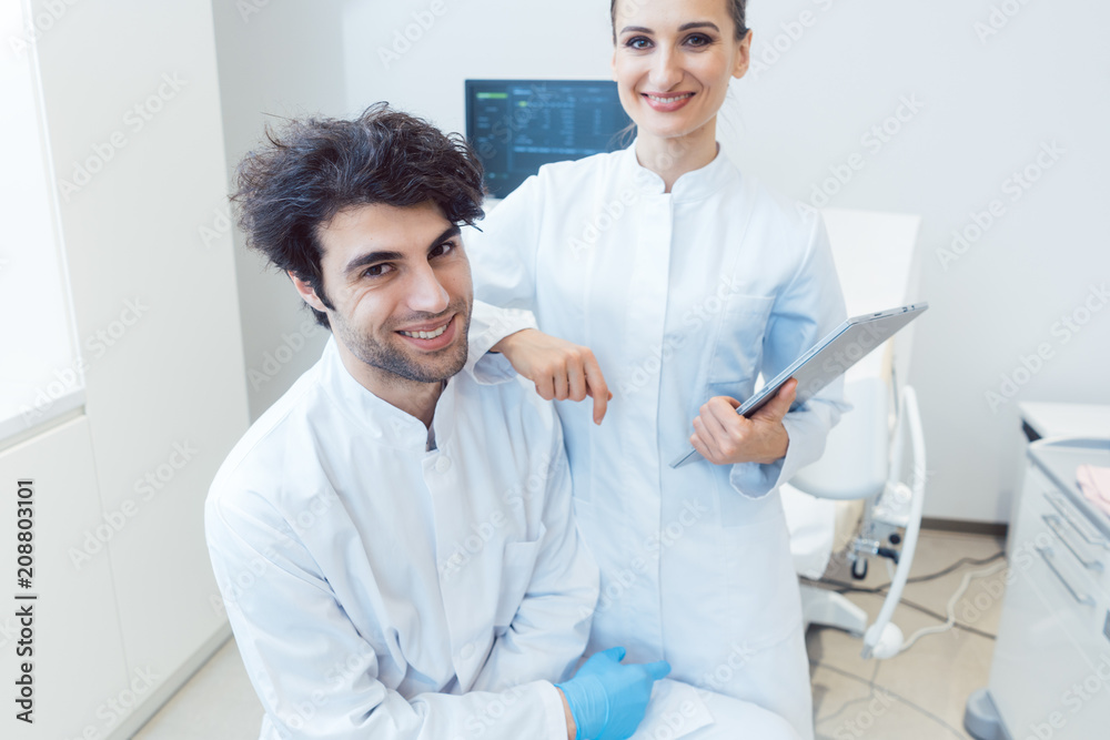 Obraz premium Arzt und Ärztin mit Tablet Computer in der Praxis