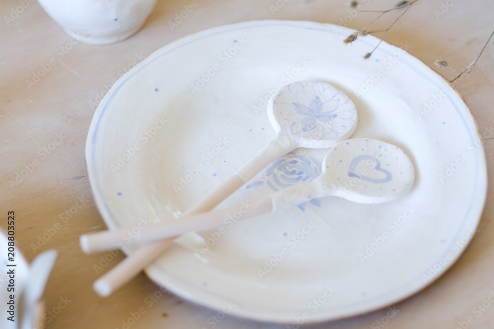 pottery handcraft hobby. exquisite handmade craft white clay plate and spoons pottery handcraft hobby. exquisite handmade craft white clay plate and spoons