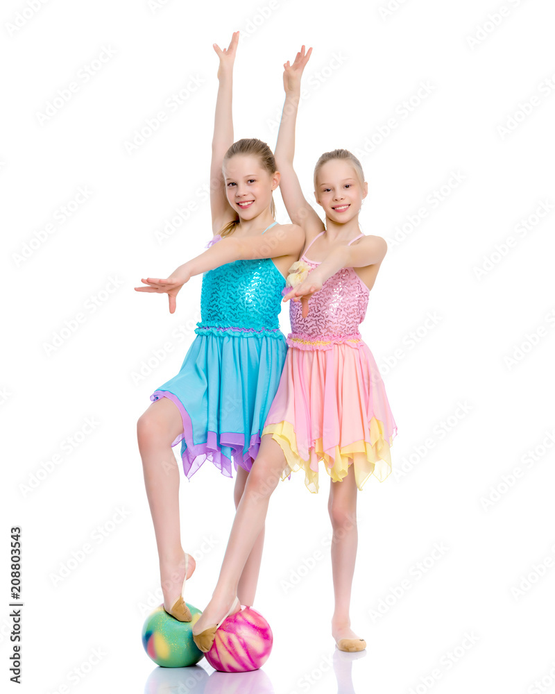 Girls gymnasts perform exercises with the ball. Girls gymnasts perform exercises with the ball.
