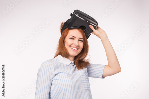 Happy young red-haired woman using a virtual reality headset