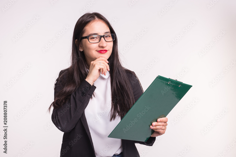 Portrait of young business woman in black jacket with paper clip in hands.
