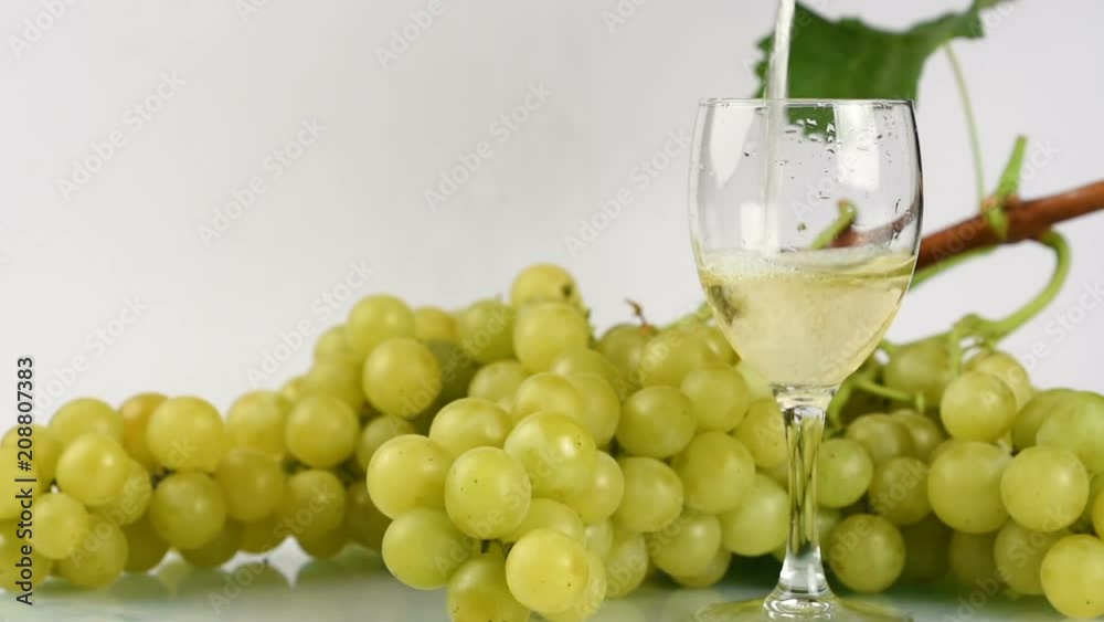 white wine poured into the glass on white background white wine poured into the glass on white background