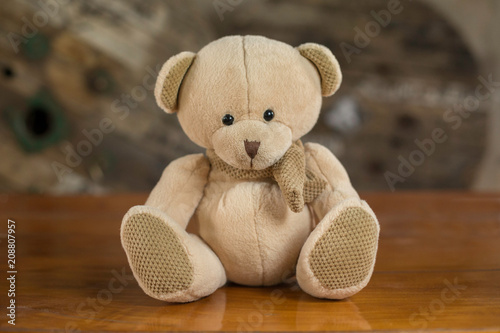 Cute teddy bear on a wooden table.