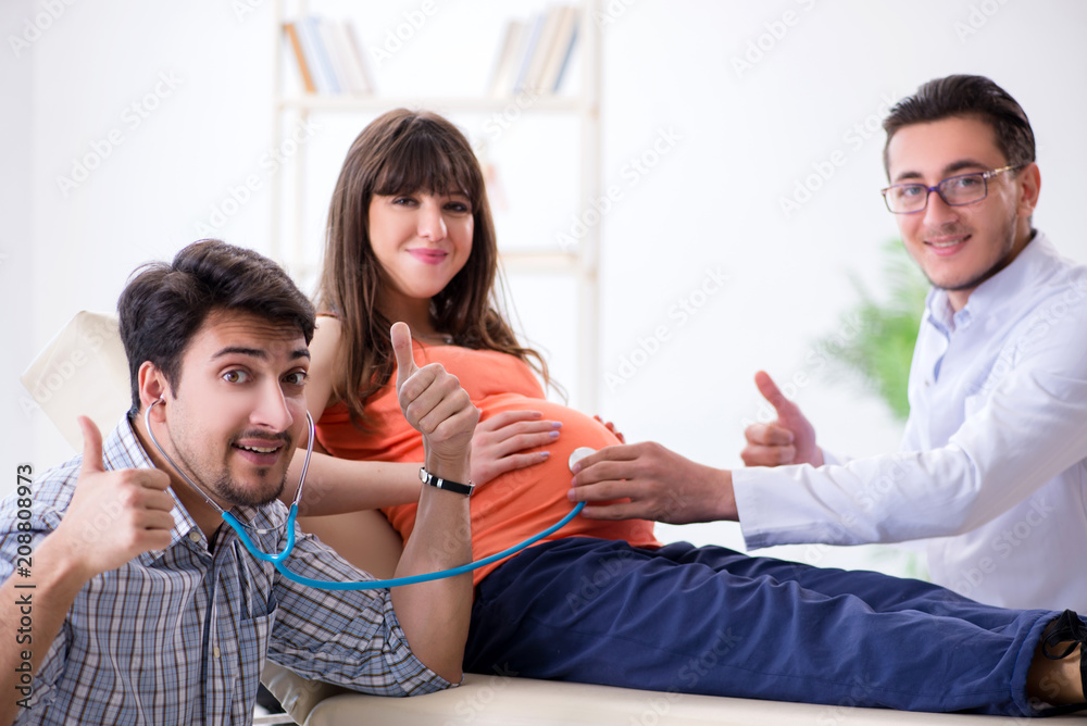 Pregnant woman with her husband visiting the doctor in clinic Pregnant woman with her husband visiting the doctor in clinic