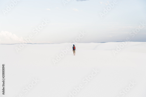 A man walking on a sand dune at White Sands National Monument in Alamogordo, New Mexico. 