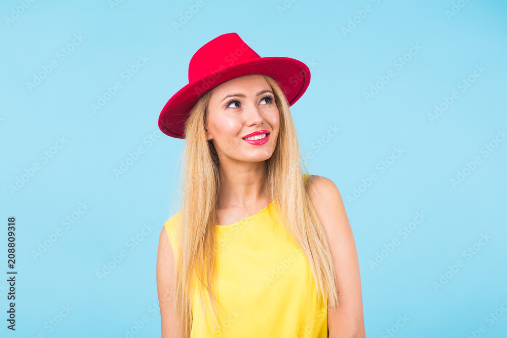 Portrait of smiling blonde woman in fashionable look on blue background. Style, fashion, summer and people concept