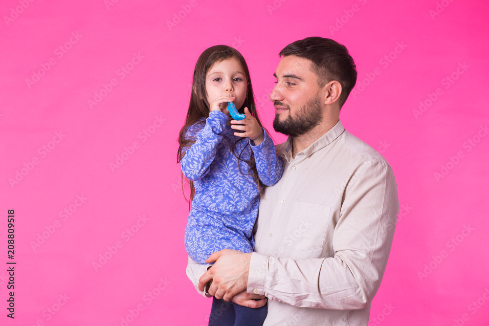 Naklejka premium Happy father with his baby daughter on pink background