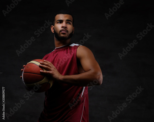 Portrait of an Afro-American sportsman. Basketball player in sportswear with a ball © Fxquadro