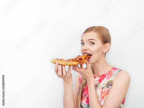 Beauty portrait of young beautiful cheerful young fresh looking woman with bright trendy make up long blond healthy hair enjoying pizza.