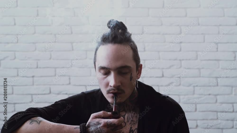 Man smoking pipe. Rasta smoker with dreadlocks. Bad habits, addiction. Unhealthy lifestyle concept. Concentration. Man smoking pipe. Rasta smoker with dreadlocks. Bad habits, addiction. Unhealthy lifestyle concept. Concentration.