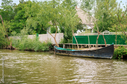Fototapeta Naklejka Na Ścianę i Meble -  Danube river and fishing boat near the shore on a summer day. Vilkovo, Ukraine
