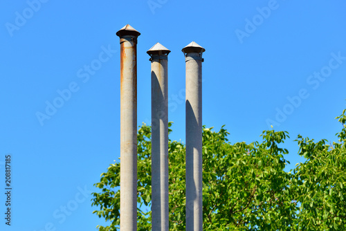 High triple chimney at the house next to the green trees photo