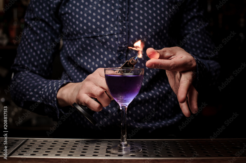 Bartender making a sweet and fresh purple summer cocktail with a smoke note