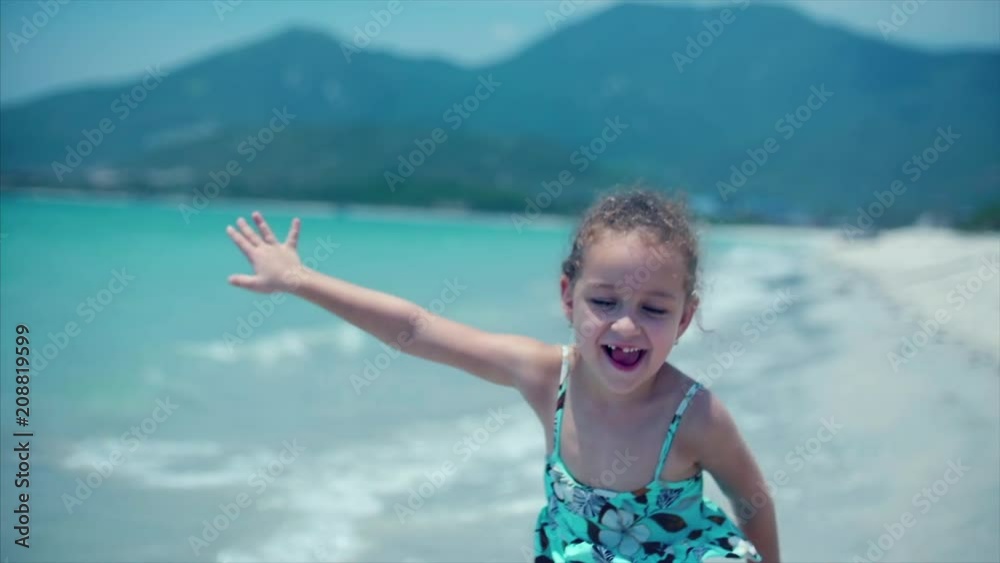 Adorable little girl runs down the beach toward her mother for a big hug and kiss. Close up shot. Stock footage Adorable little girl runs down the beach toward her mother for a big hug and kiss. Close up shot. Stock footage
