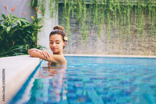 Swimming pool spa retreat relaxation. Relaxing woman lenjoying serenity in summer holiday travel vacation at resort hotel.