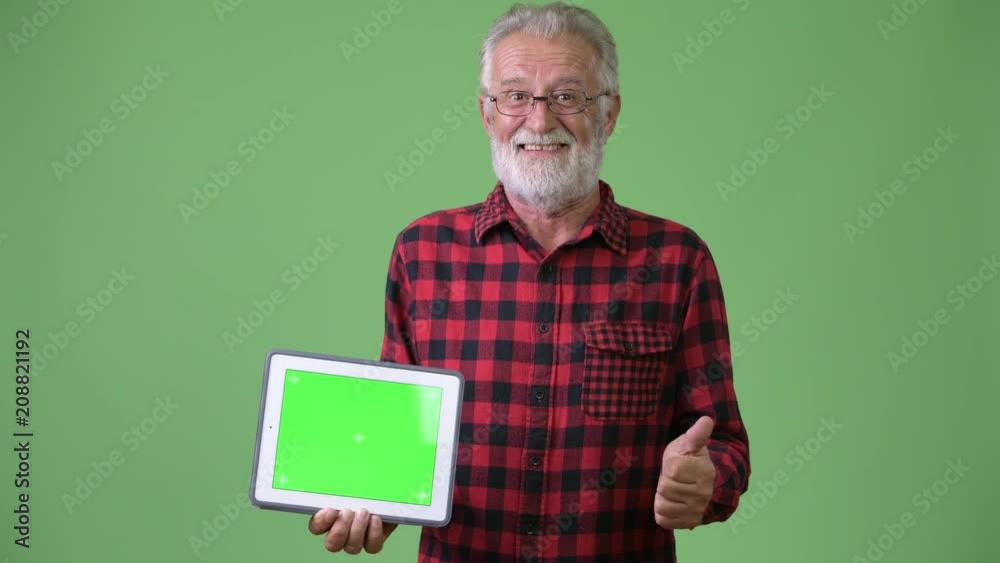Handsome senior bearded man against green background Handsome senior bearded man against green background