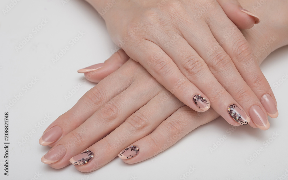 Cute manicure on female hands. Woman hands with black and white design manicure on vintage wooden background. Nails and skin treatment. Matte manicure on female hands. Cute manicure on female hands. Woman hands with black and white design manicure on vintage wooden background. Nails and skin treatment. Matte manicure on female hands.