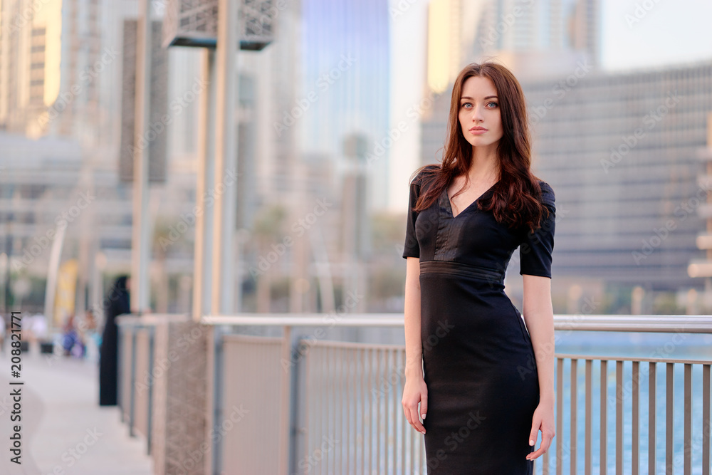 Portrait of beautiful caucasian woman with charming smile and long hair walking on the Dubai street.