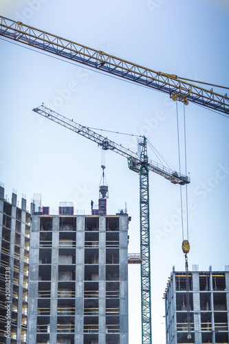 Construction cranes work on the site of residential apartment buildings.