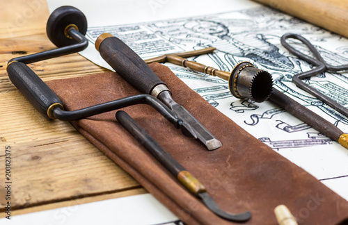 medical instruments medieval surgery drill on a leather cover on background wooden table