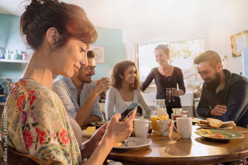 Group of multi-ethnic friends gathered around a table for breakfast