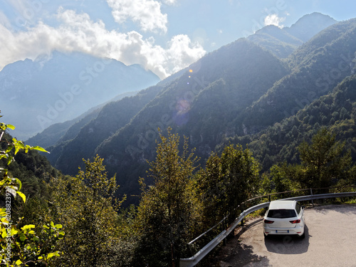 White car standing on the wild mountain road with forest hill in background © Maciej Gerszewski