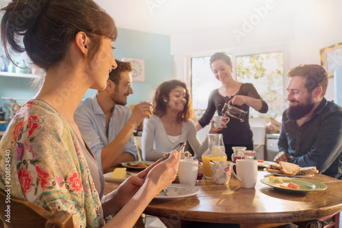 Group of multi-ethnic friends gathered around a table for breakfast