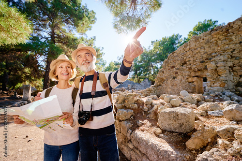 Family, age, tourism and travel concept. Happy senior couple with map at ancient sightseeing.