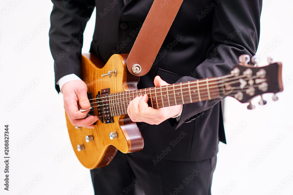Close up of young man playing electric guitar on white background.